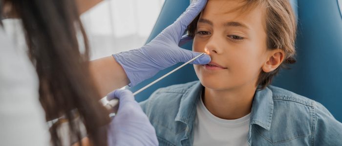 Adult female doctor checking patients nose during medical examination